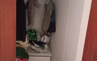 interior de un armario o vestidor, con ropa colgada y doblada, así como estantes y cajones para almacenamiento