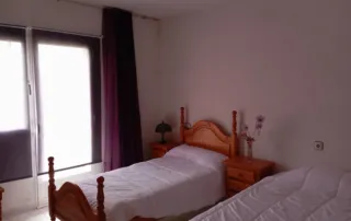 habitación con dos camas individuales de madera.