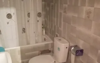 baño que incluye un inodoro, una bañera con cortina de ducha y un bidé.