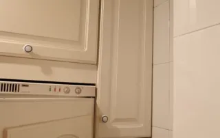 una vista de una cocina, centrándose en una parte de los armarios superiores y un electrodoméstico empotrado.