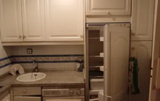 cocina equipada con armarios blancos y encimera de granito.