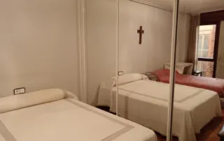una habitación con dos camas individuales y un armario con puertas de espejo.